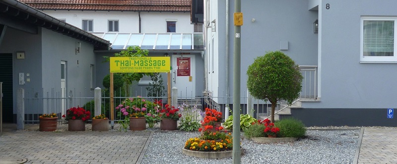 Zugang zur Praxis und Parkplatz vor dem Schild